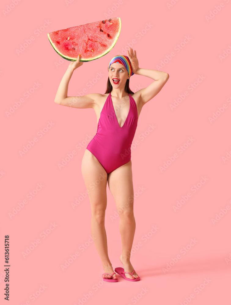 Beautiful young woman in swimsuit and with watermelon on pink background