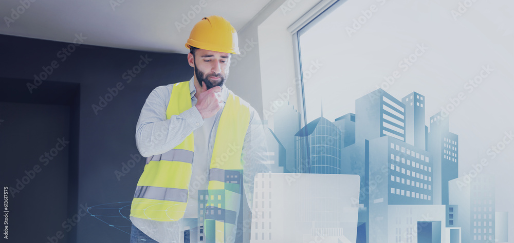 Male construction worker with laptop and new digital project of modern city in office