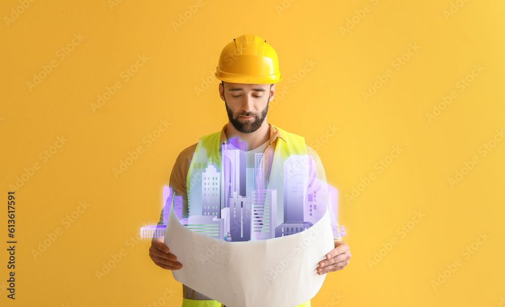 Male construction worker with draft and new digital project of modern city on yellow background