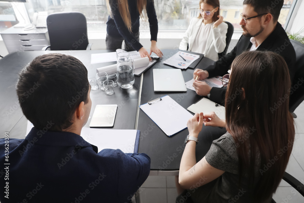 Group of people working on business plan at table in office