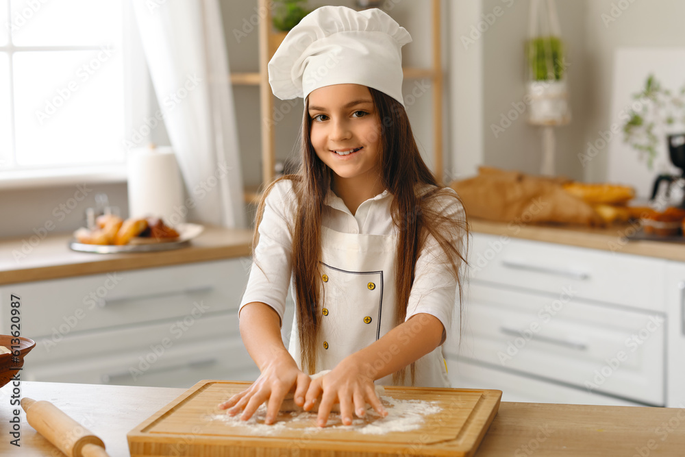 Little baker making dough in kitchen