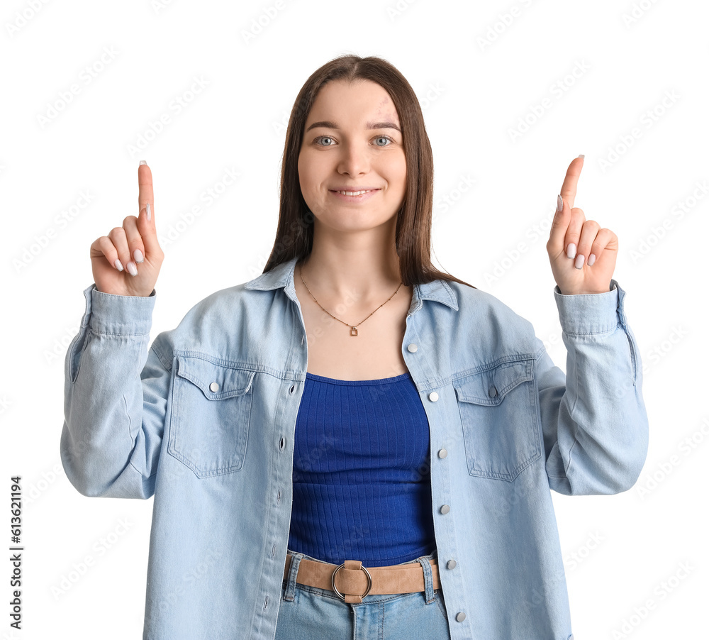 Young woman in shirt pointing at something on white background