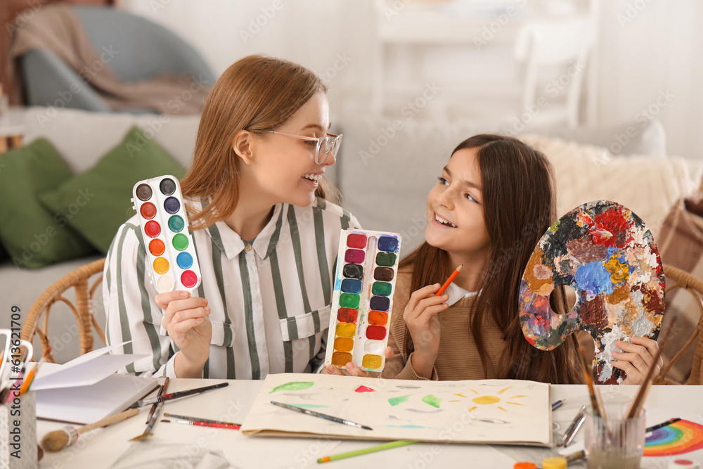 Little girl and her drawing teacher with paints at home