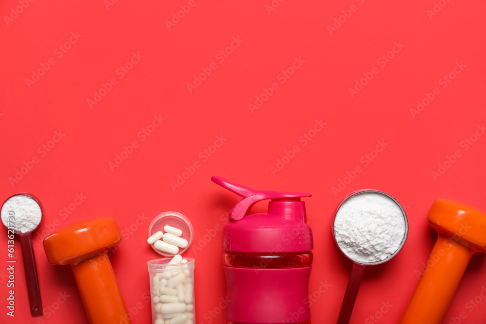 Composition with bottle of water, dumbbells, amino acid pills and powder on red background