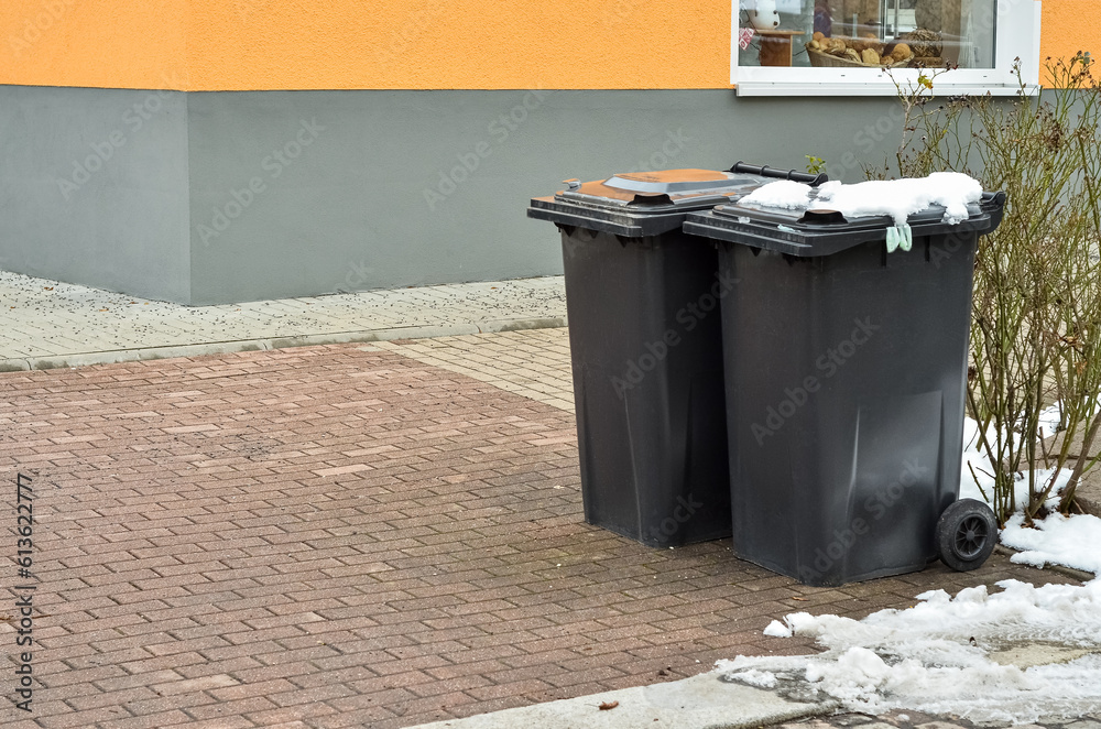 View of garbage containers in city on winter day