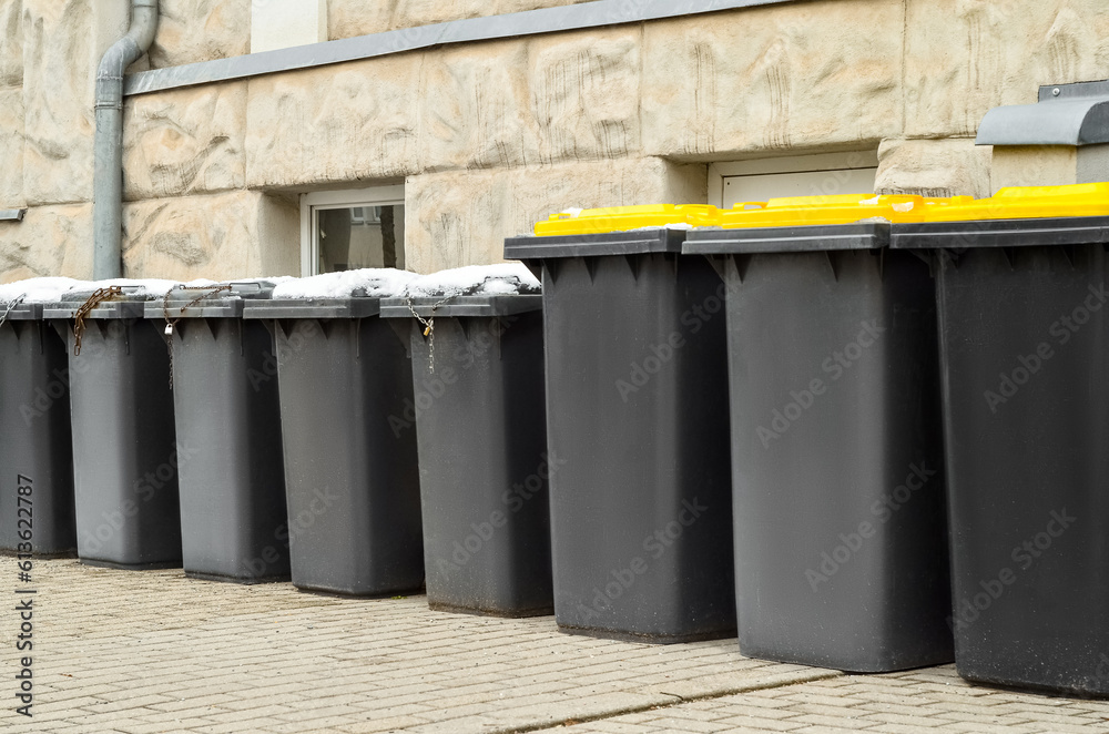 View of garbage containers in city on winter day