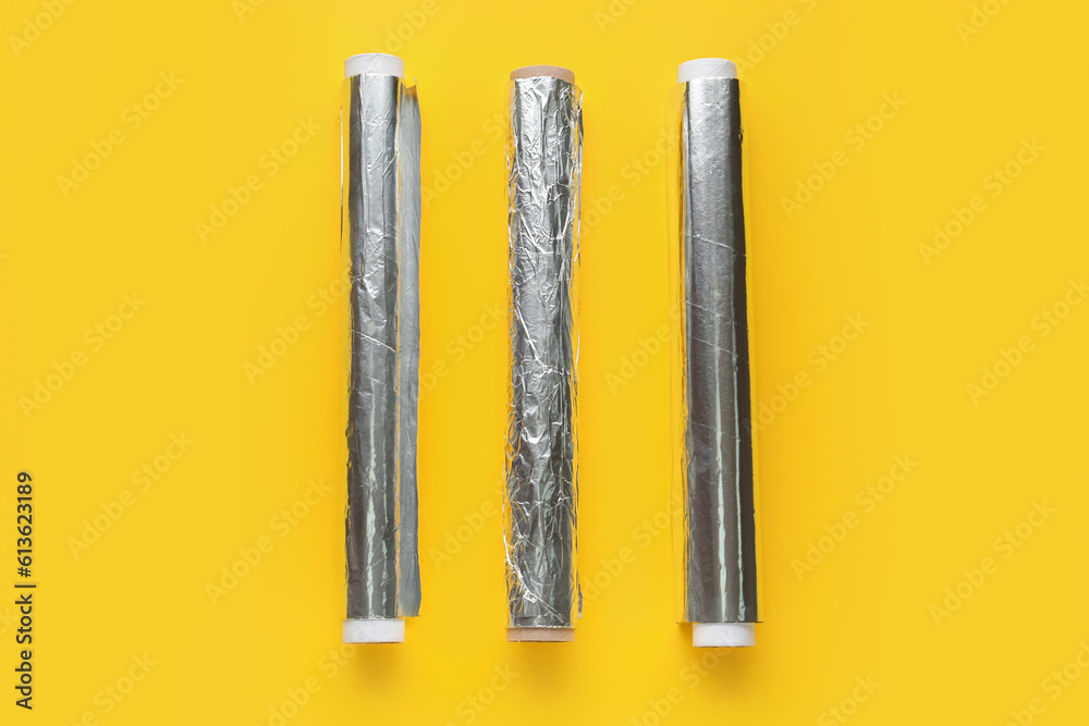 Aluminium foil rolls on yellow background