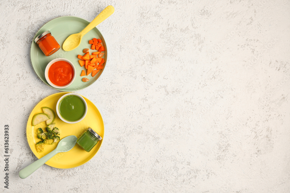 Plates with healthy baby puree and fresh vegetables on light background