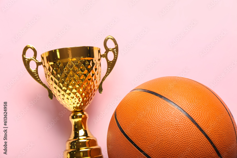 Gold cup with ball on pink background