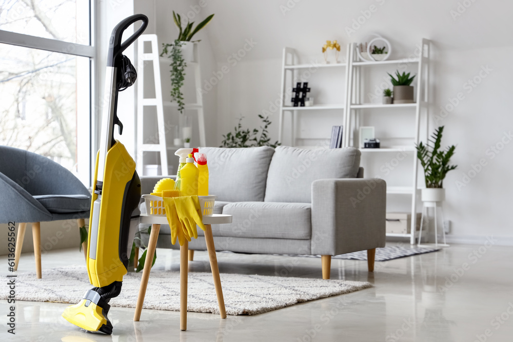 Table with cleaning supplies and hoover in living room