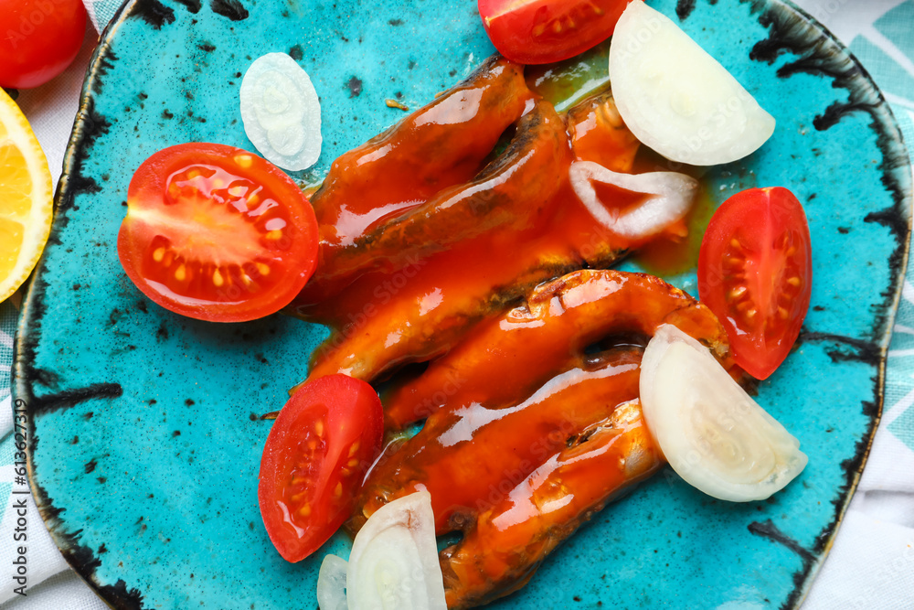 Plate with canned fish in tomato sauce and vegetables, closeup