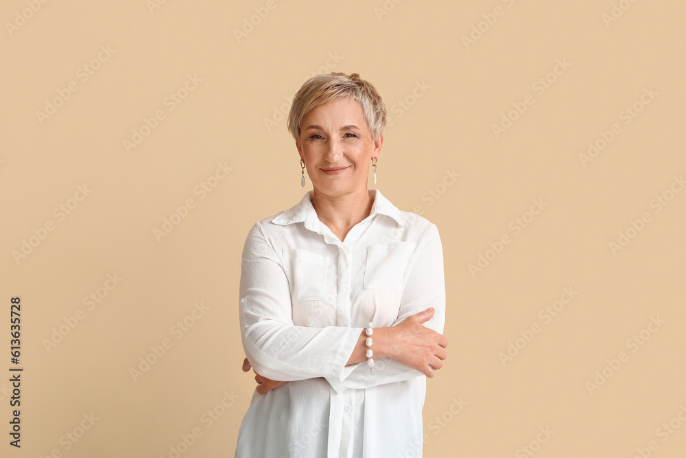 Mature blonde woman in white shirt on beige background