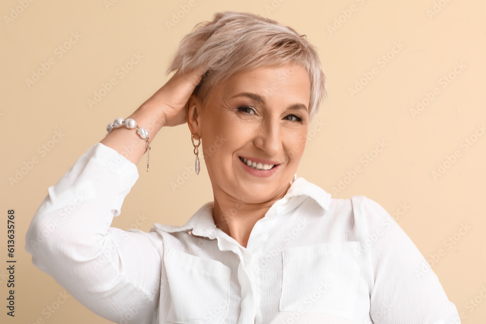 Mature blonde woman on beige background, closeup