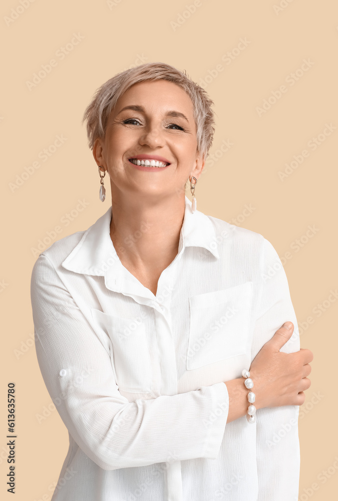 Mature blonde woman in white shirt on beige background