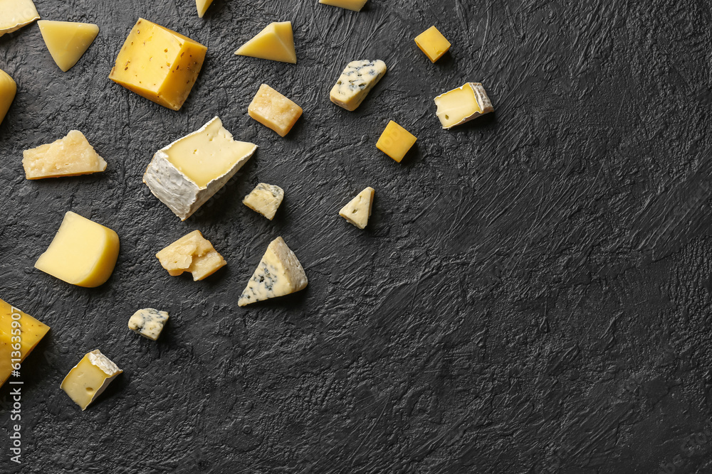 Pieces of tasty cheese on dark background