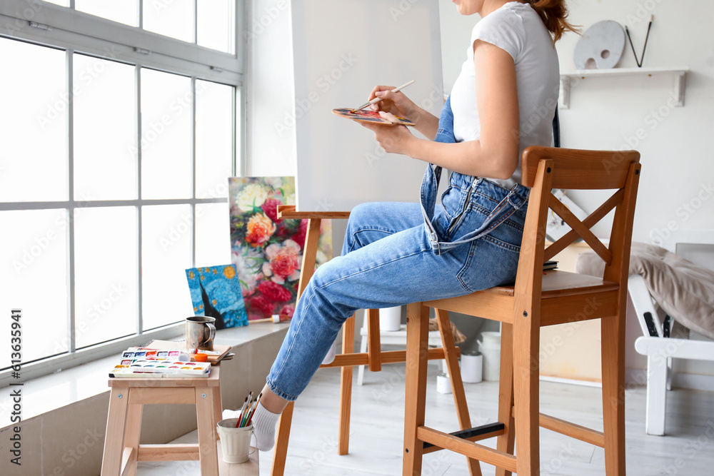 Female artist painting picture in  workshop