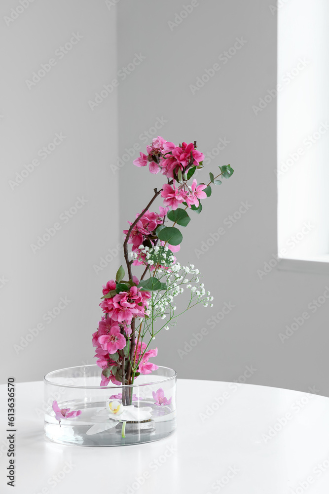 Beautiful ikebana on dining table in light room, closeup