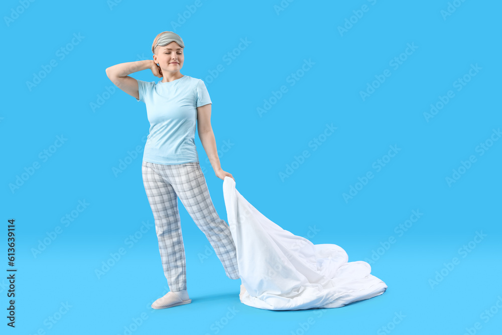 Young woman with soft blanket on blue background