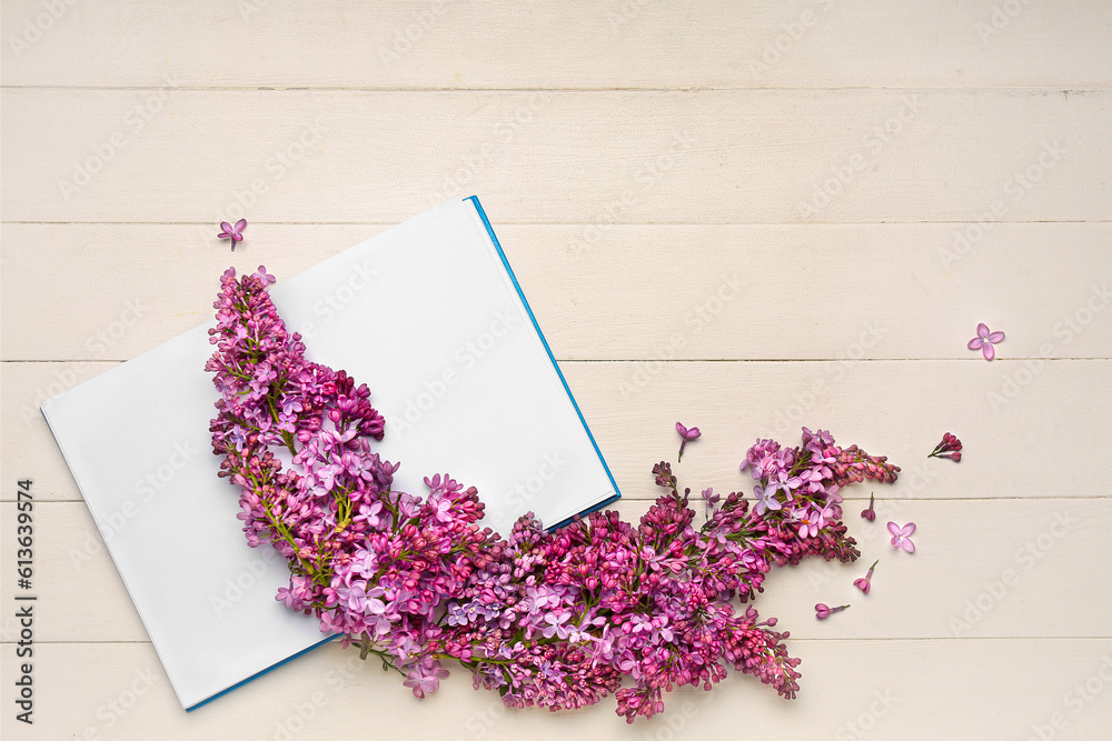 Lilac twigs with open notebook on white wooden table