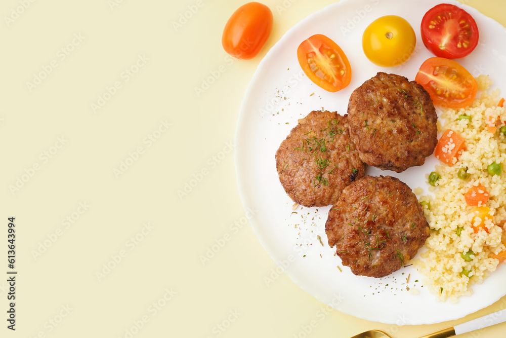 Cutlets with bulgur, boiled vegetables and tomatoes on light yellow table in kitchen