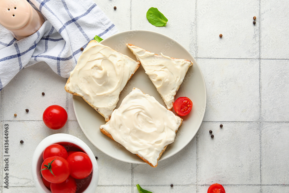 Plate of tasty toasts with cream cheese on white tile background