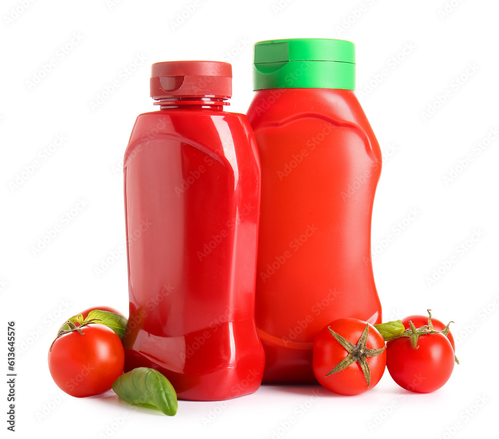 Bottles of ketchup and tomatoes on white background