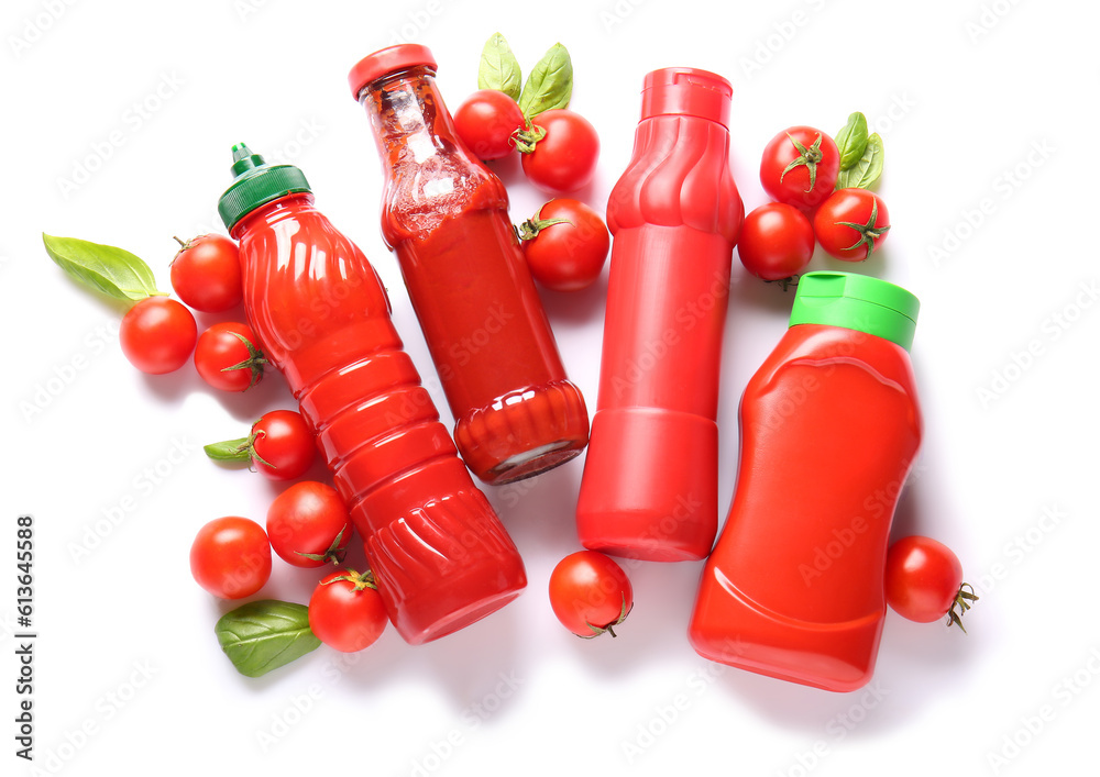 Bottles of ketchup and tomatoes on white background