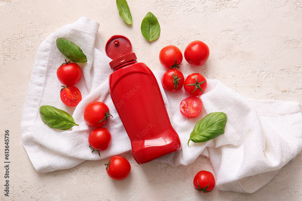 Bottle of ketchup and tomatoes on white background