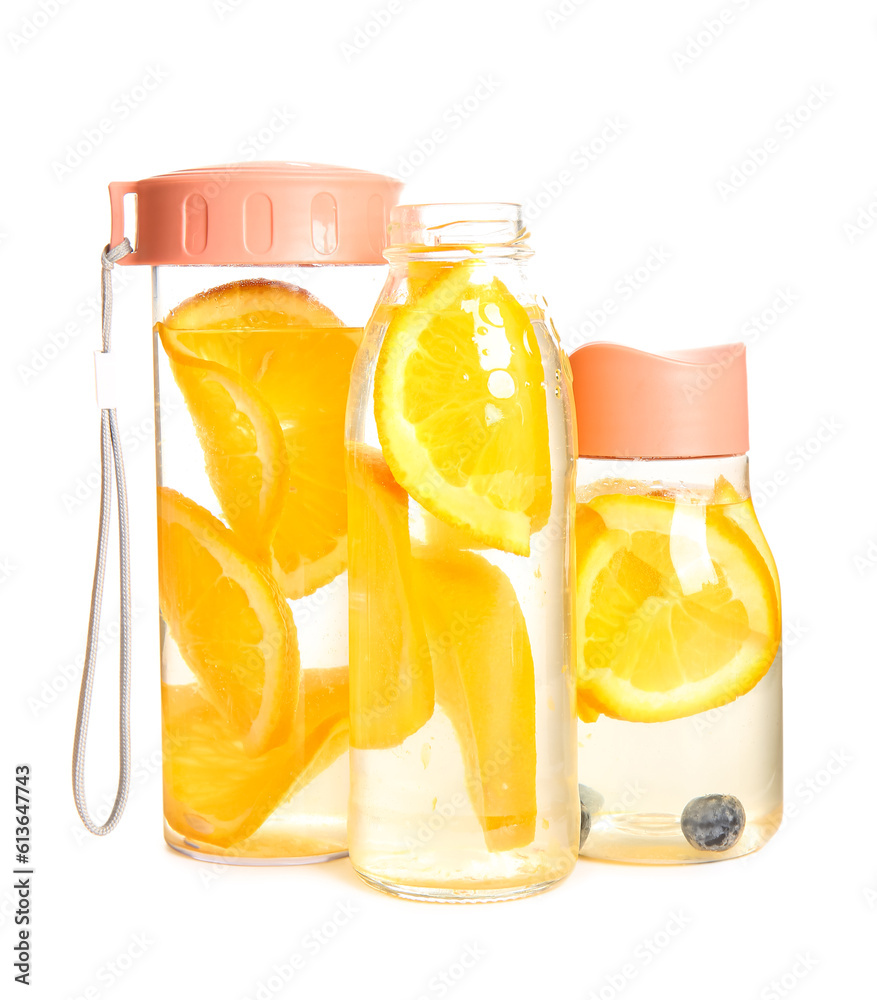 Bottles of infused water with orange slices on white background