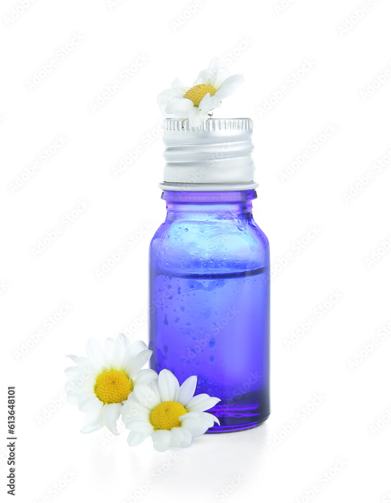 Bottle of healthy essential oil and chamomile flowers on white background