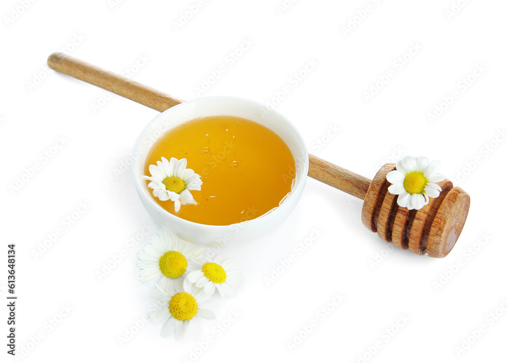 Bowl of honey, dipper and chamomile flowers on white background