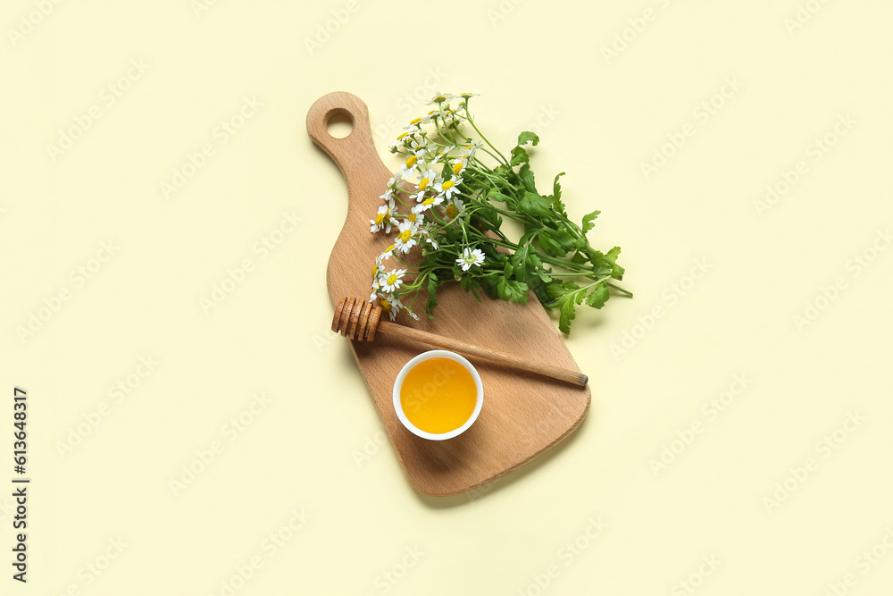 Wooden board with bowl of honey and fresh chamomile flowers on color background