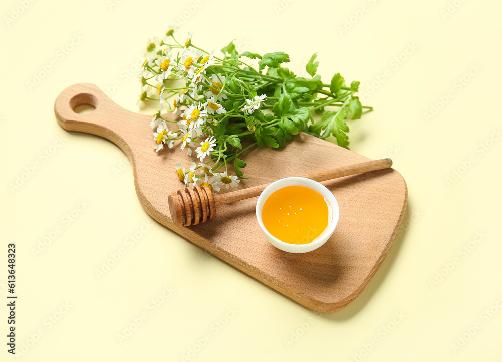 Wooden board with bowl of honey and fresh chamomile flowers on color background