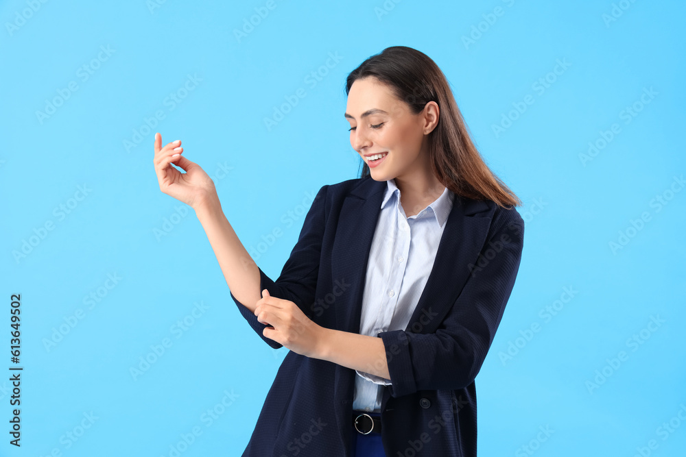 Young woman in stylish suit on blue background