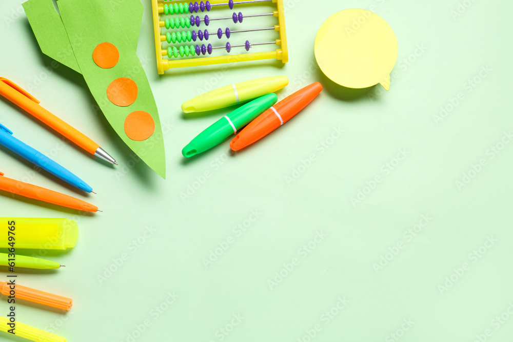 Paper rocket with abacus, different stationery and speech bubble on green background