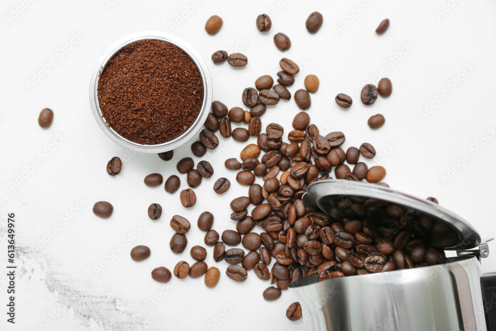 Bowl with coffee powder and beans on white marble background