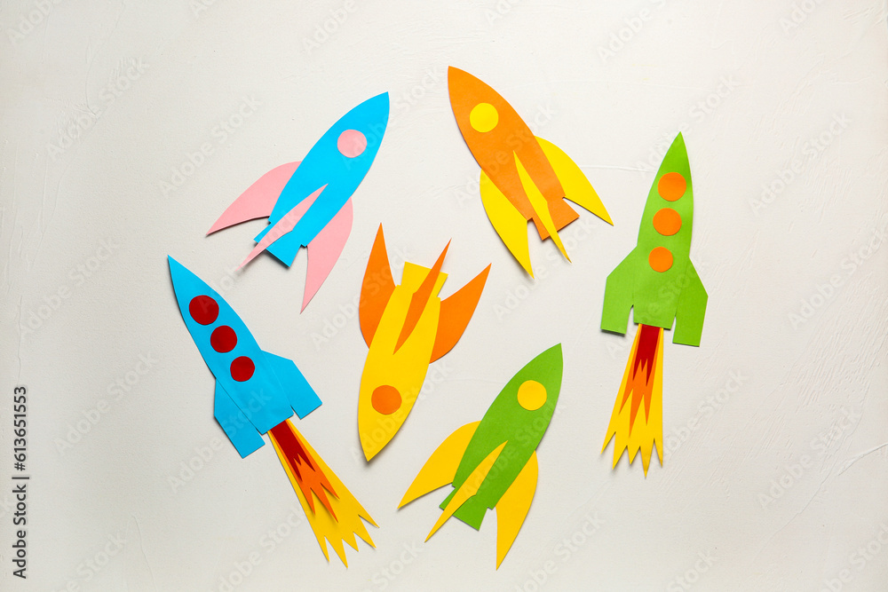 Color paper rockets on white background