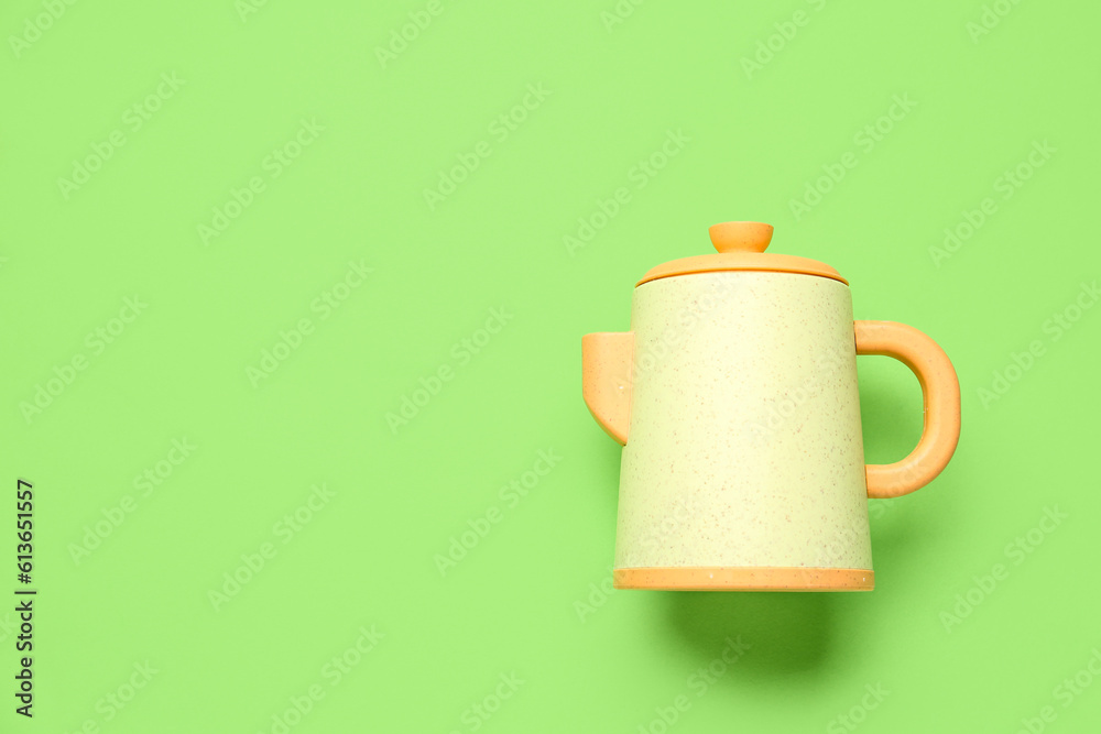 Teapot for baby on green background