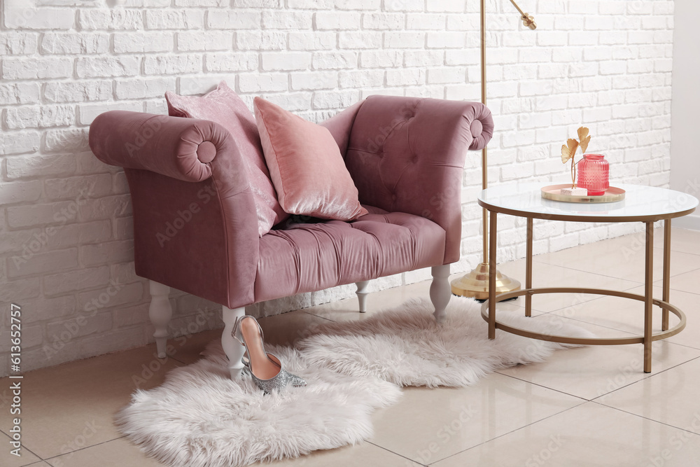 Cozy pink armchair, coffee table and fur rug white brick wall