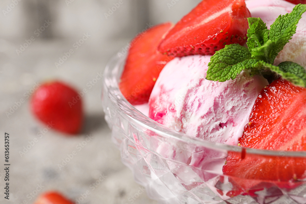 Bowl of strawberry ice cream with berries and mint on table, closeup