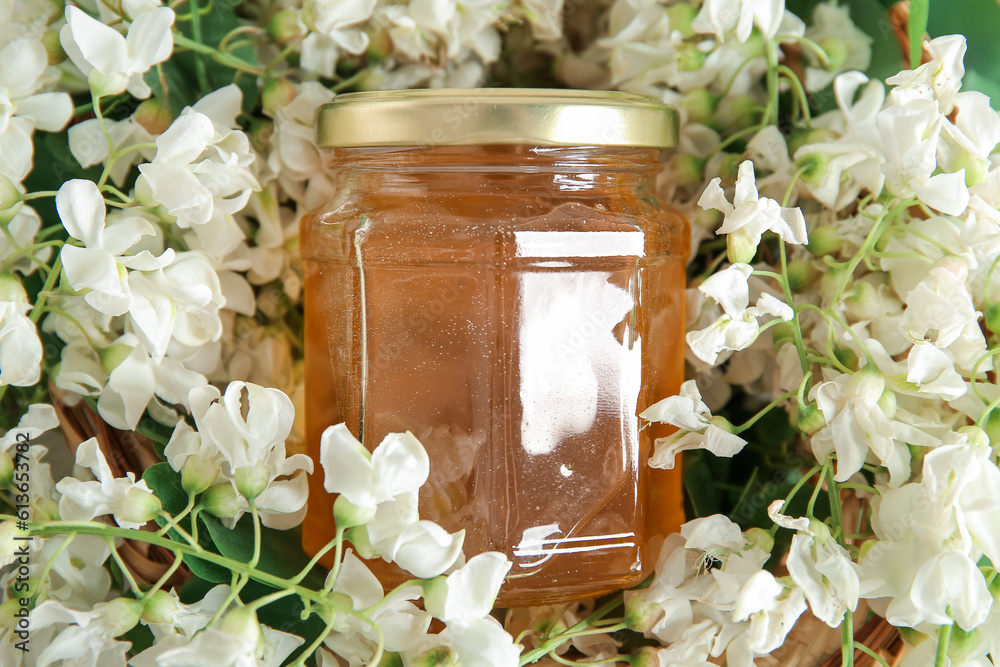 Jar of honey with flowers of acacia, closeup