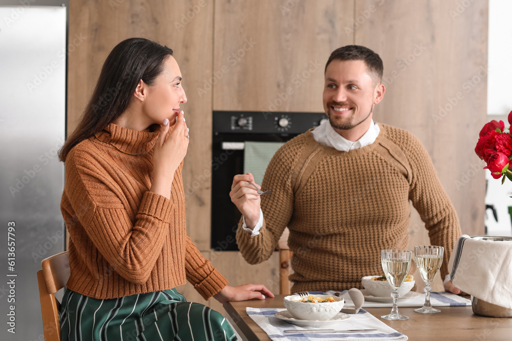 Happy engaged couple having dinner in kitchen