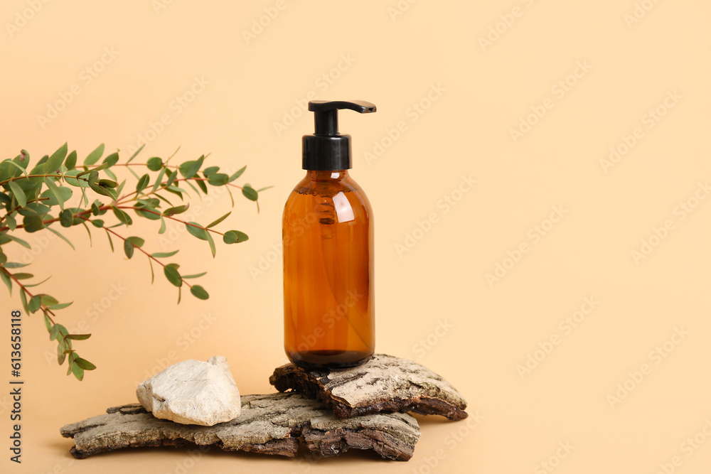 Bottle of cosmetic product, tree bark and eucalyptus branch on color background