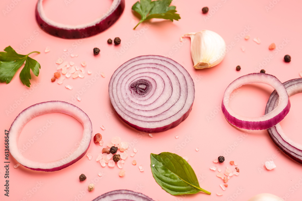 Fresh onion slices and spices on pink background, closeup