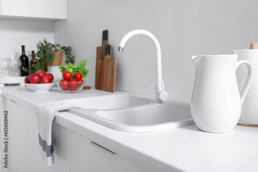 White countertop with sink and vegetables in modern kitchen