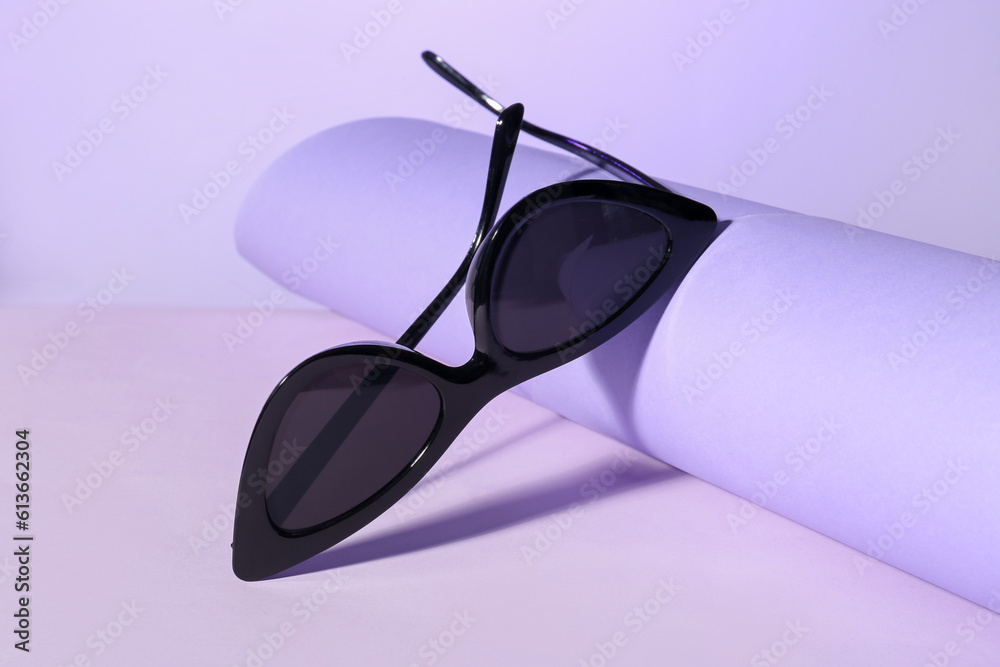 Stylish sunglasses on lilac background