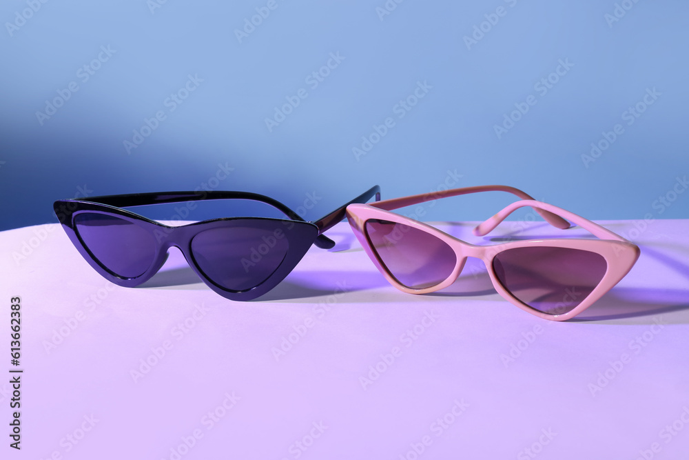 Different stylish sunglasses on colorful background