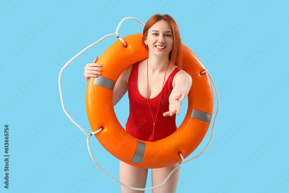 Female lifeguard with ring buoy on blue background