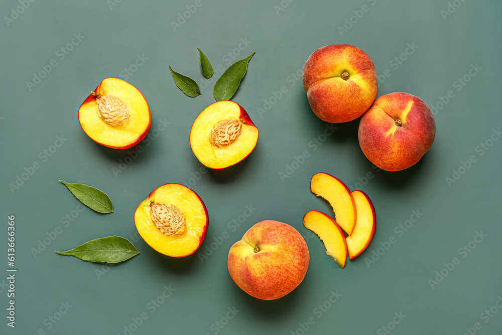 Sweet peaches and leaves on green background