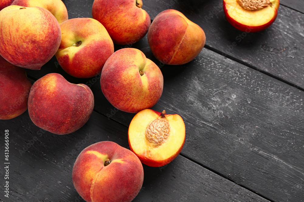 Many sweet peaches on black wooden background